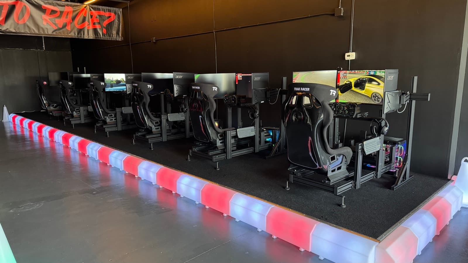 Full row of racing simulators on the LED-lit platform
