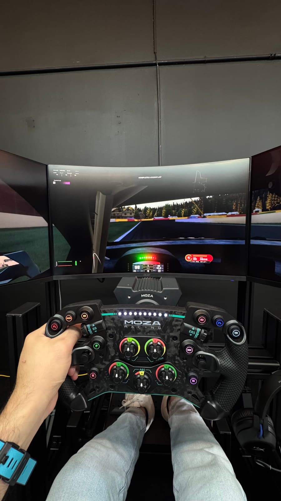 Driver POV of the force-feedback wheel and triple-monitor setup