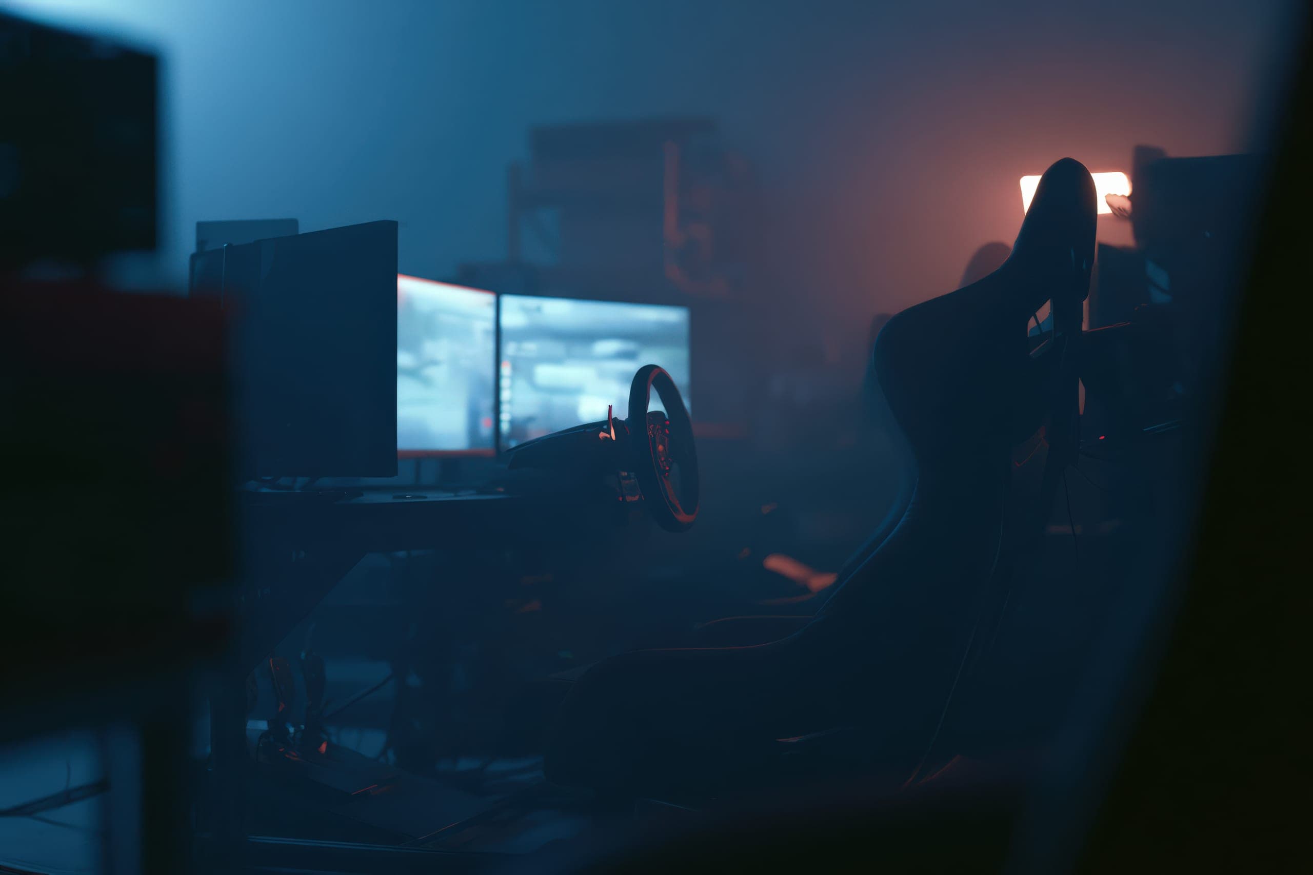 Racing simulators glowing at night inside the Racing Station lounge